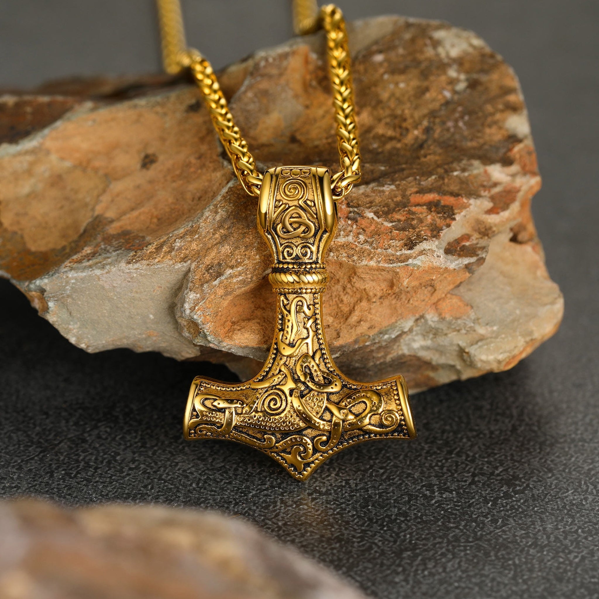 Guldfärgat halsband av stål med den nordiske åskguden Tors hammare Mjölner