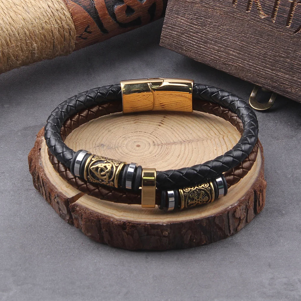 Nordiskt armband av svart och brunt läder med guldfärgade stålsmycken