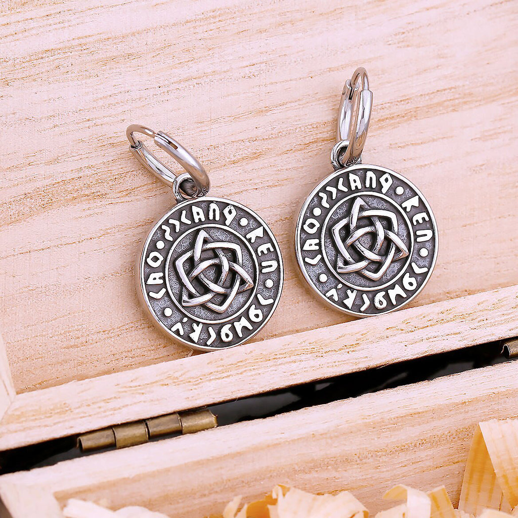 Runda örhängen prydda med triquetra-symbol och runor