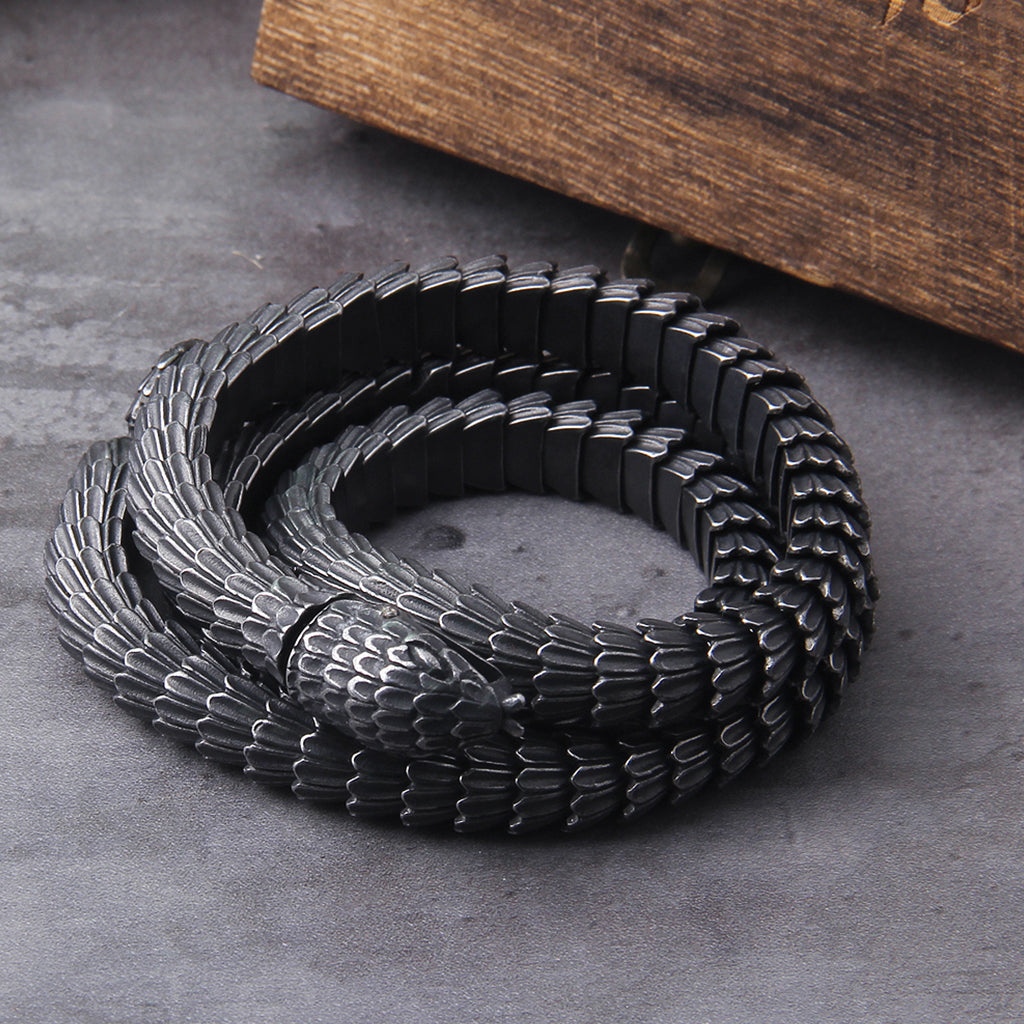 Svart herrhalsband föreställande svanssväljande orm