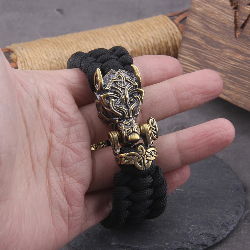 Taktiskt armband med ett mässingsfärgat varghuvudslås och tre dekorativa skäggpärlor