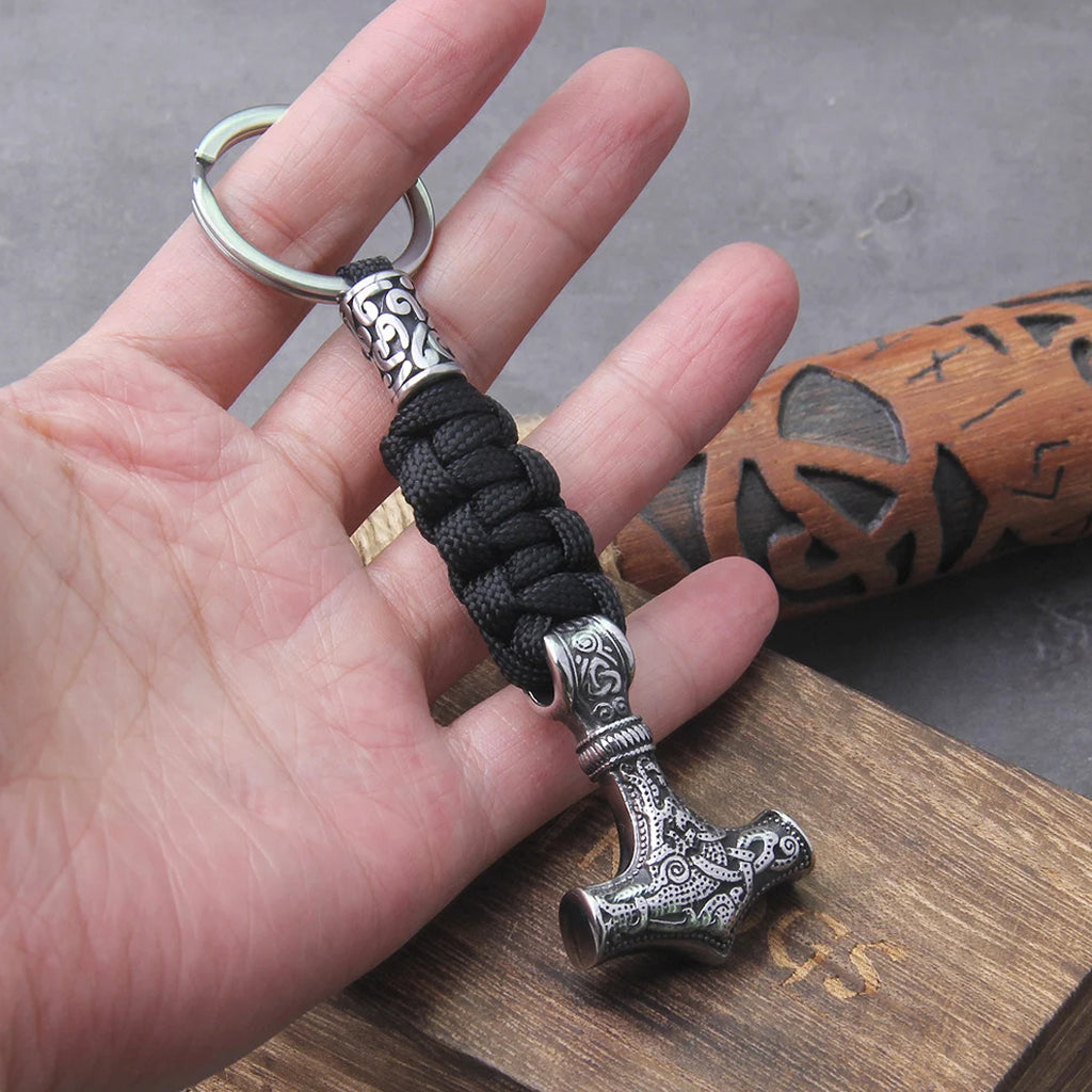 Mjölner-amulett hängande i ett svart paracord-nyckelband