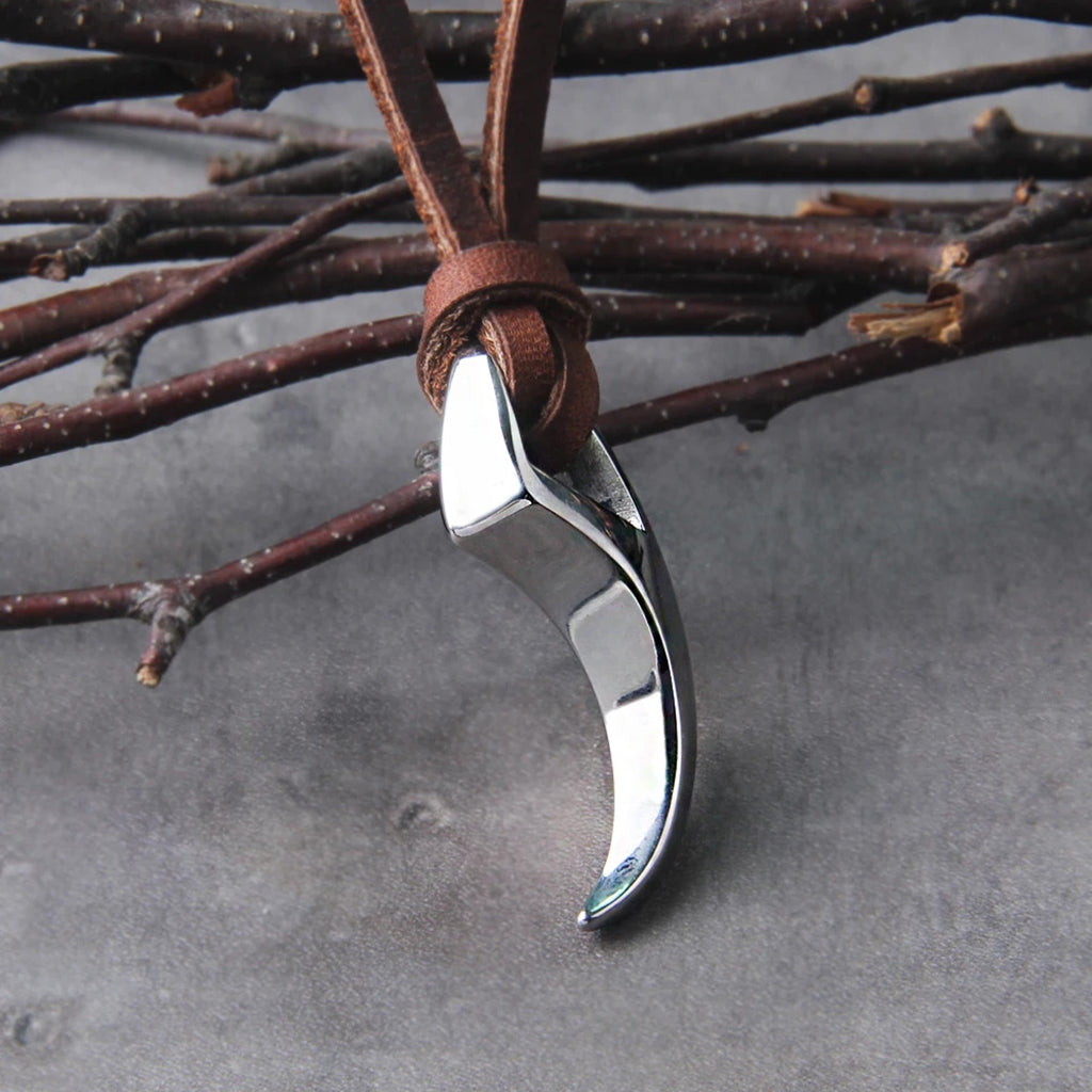 Vargtand halsbandssmycke av rostfritt stål, hängande i ett brunt läderhalsband