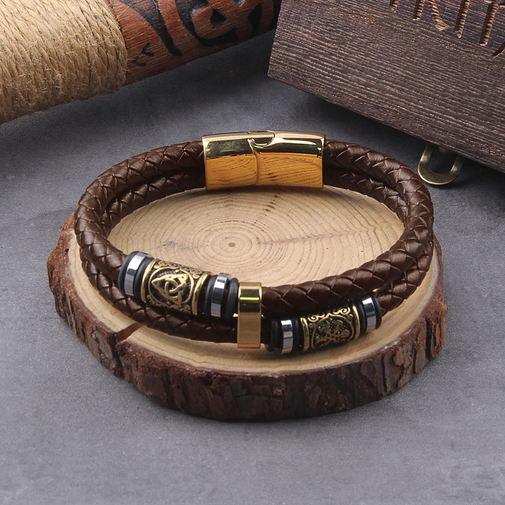 Viking armband med bruna läderremmar och små smycken av guldstål