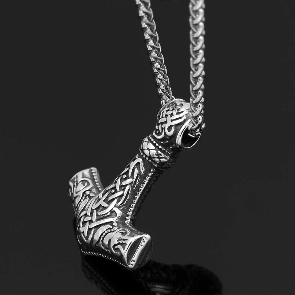 Stålfärgad amulett formad som den nordiske åskgudens verktyg