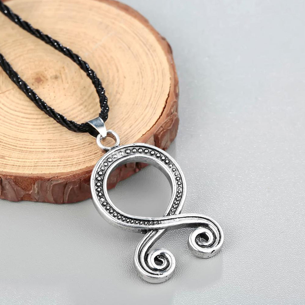 Stålfärgad trollkors-amulett som hänger i en svart läderrem