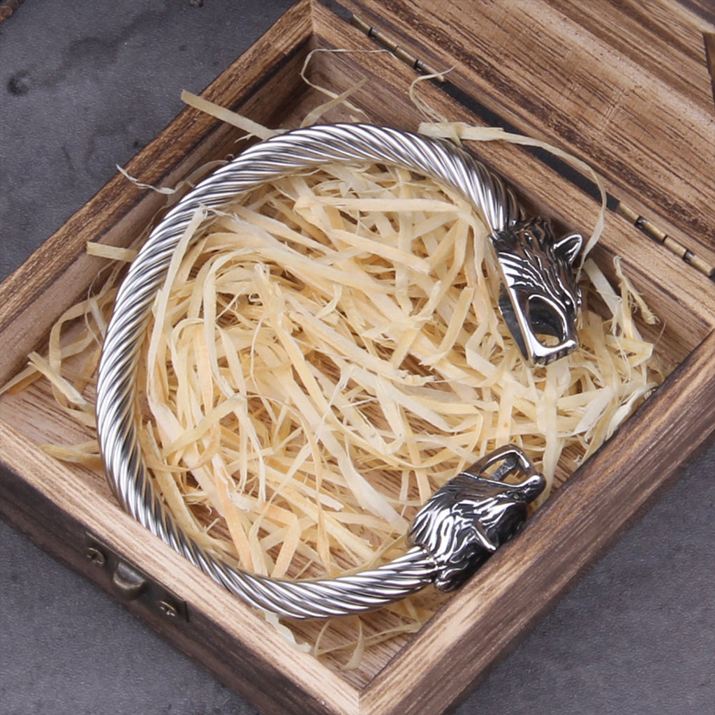 Silverfärgat manschettarmband smyckat med vargar i spetsarna