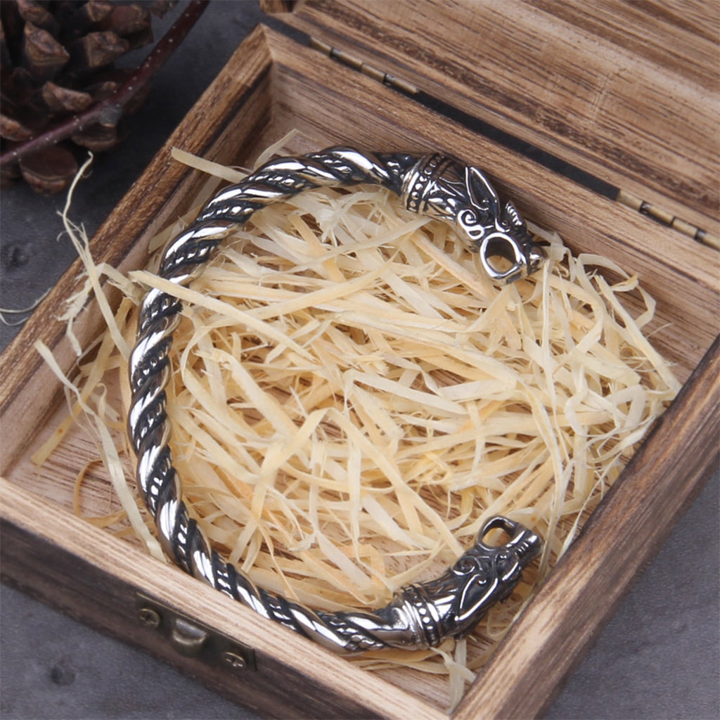 Stålfärgat vikinga armband med snidade varghuvuden symboliska för Odens vargar