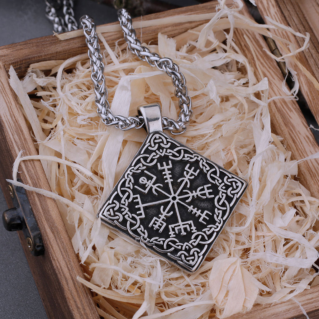 Fyrkantigt hängsmycke dekorerat med det vägvisande tecknet vegvisir