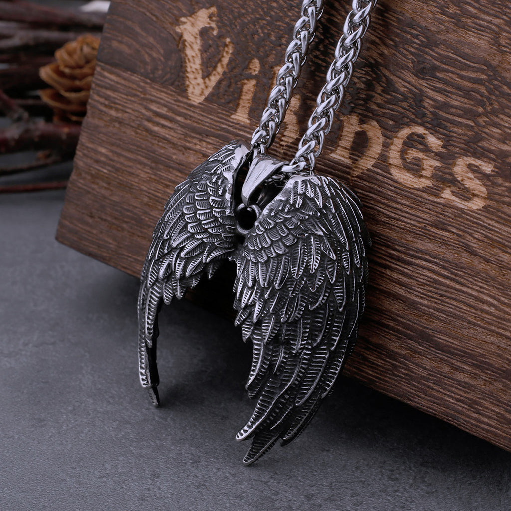 Silverfärgat hängsmycke i form av av två nedåtvända fjädervingar