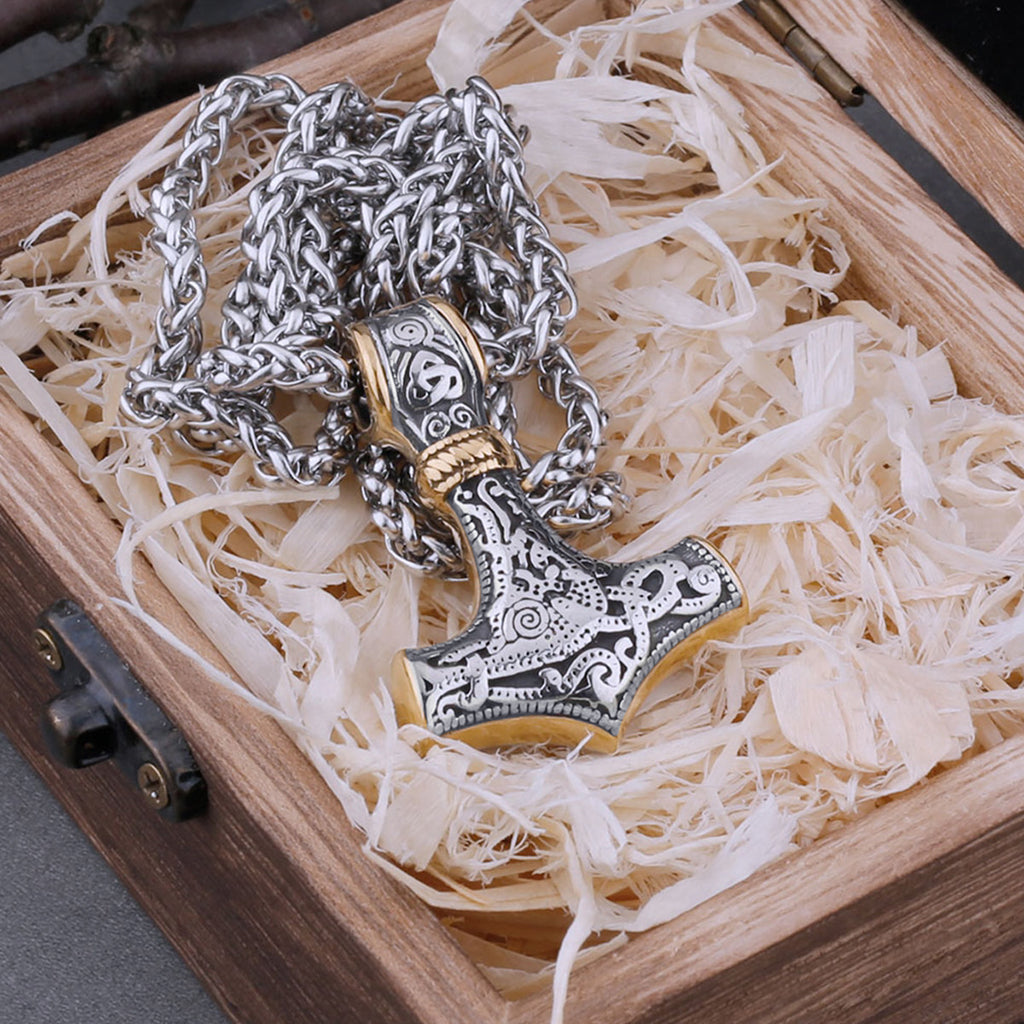 Vikingahalsband i stål med en guldfärgad torshammare som hänge