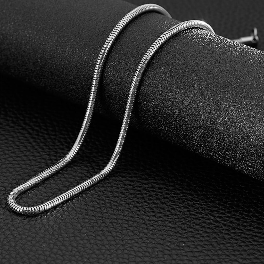 Herrhalsband i stål avbildande ormskinn