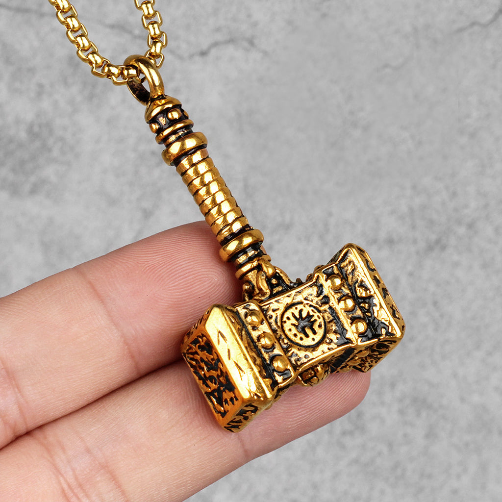 Guldfärgat hängsmycke föreställande åskguden Tors verktyg