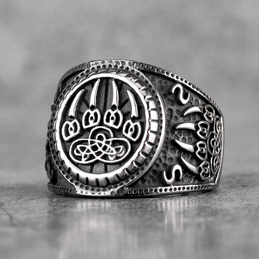 Mörk vikinga ring i stål med fotavtryck från björn