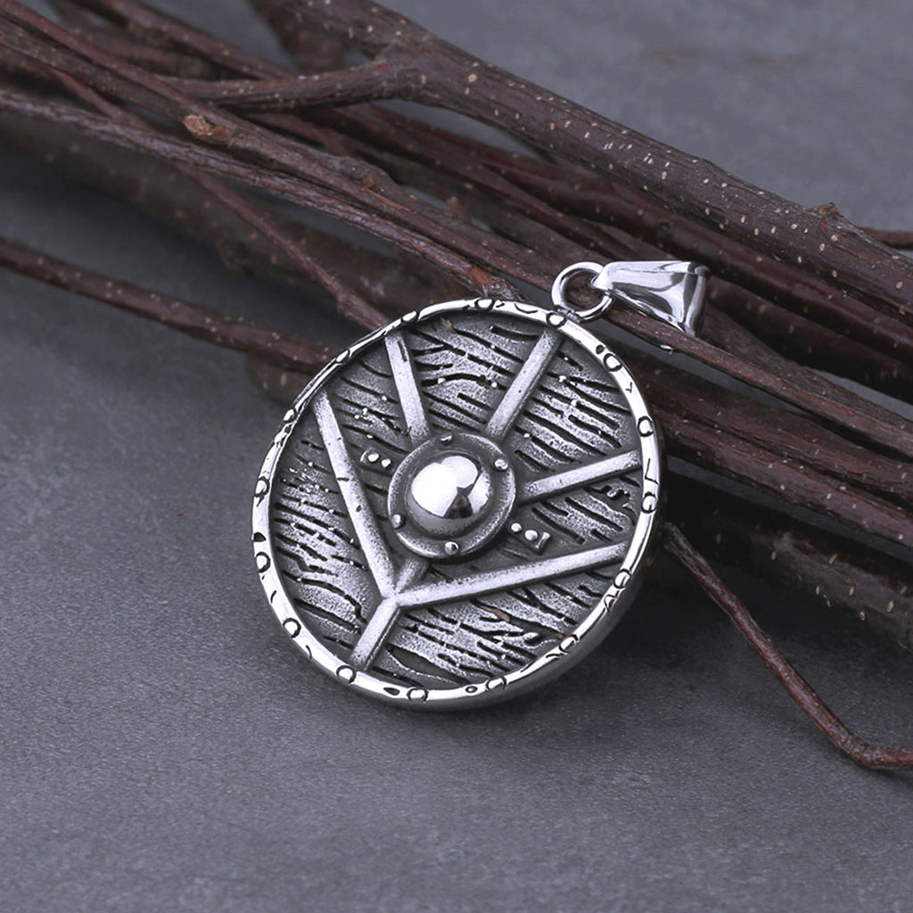 Cirkelformat hängsmycke graverat med symbol kopplad till sköldmön Lagertha