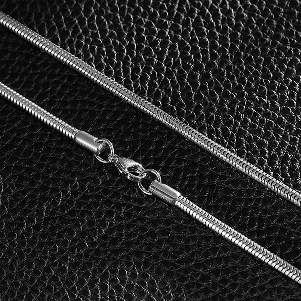 Stålfärgad halskedja föreställande ormskinn