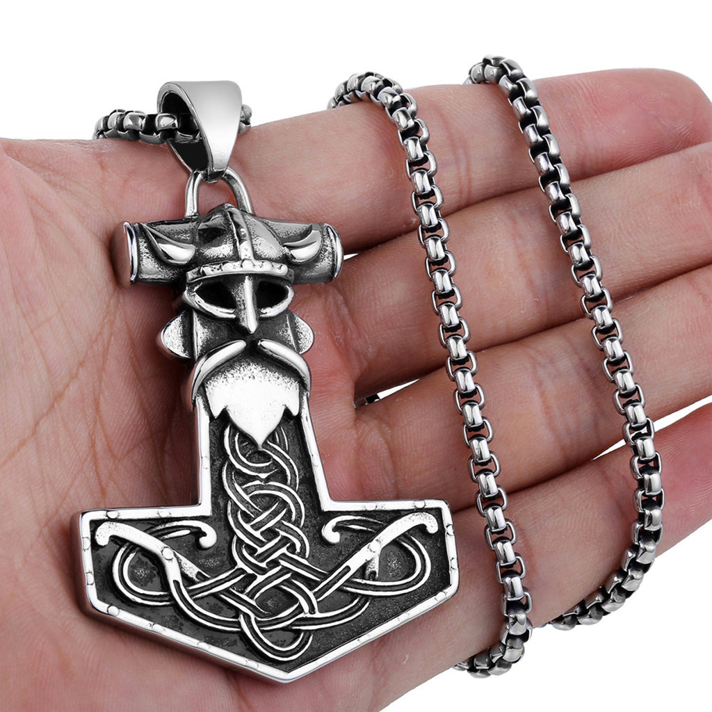 Torshammare graverad med den nordiske åskgudens ansikte