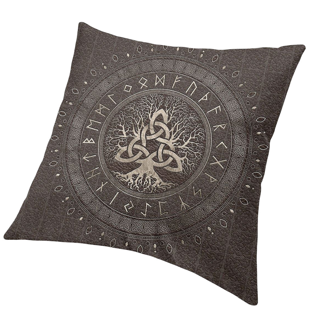Mörkbrun kudde med gråfärgat motiv av trädet Yggdrasil där grenarna formar en triquetra