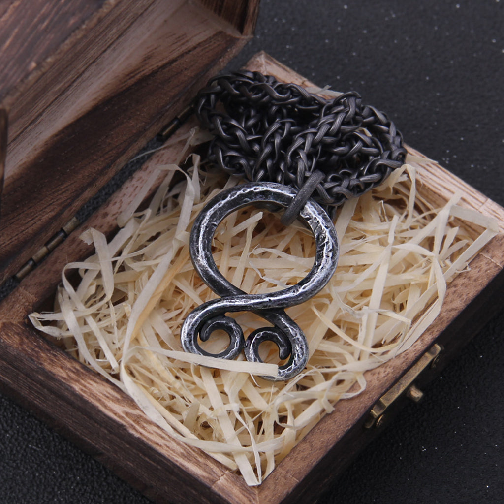 Järnfärgad trollkors-amulett som är baserad på Kari Erlands smide