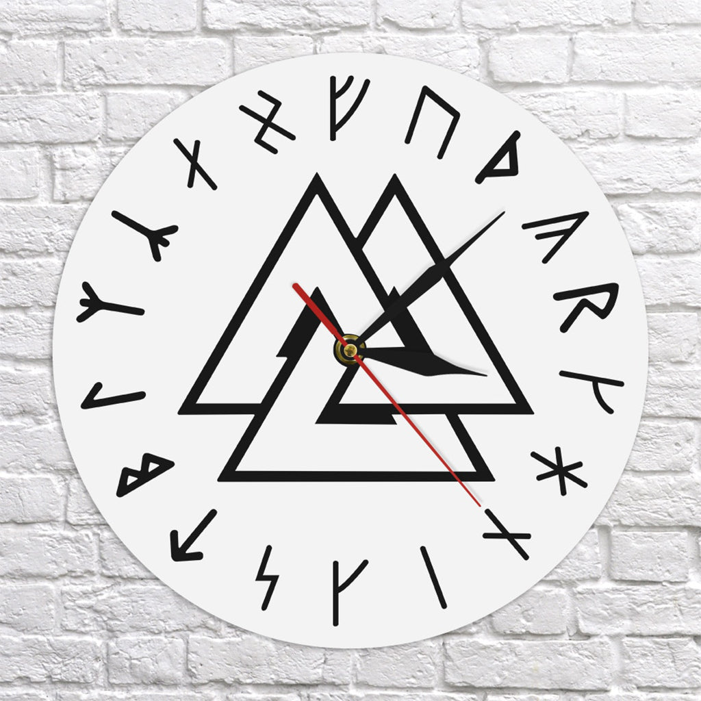 Cirkulärt väggur med motiv av Odens symbol i svart färg på framsidan