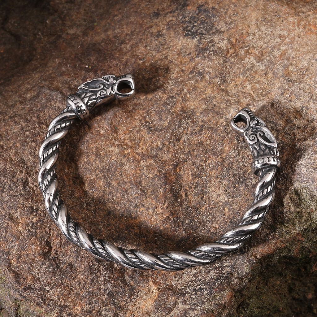 Fornnordiskt manschettarmband i sterlingsilver med dekorativa vargar i ändarna