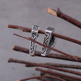 Silverfärgade ringörhängen formade som den fornnordiska symbolen valknut
