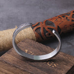 Stålfärgat manschettarmband smyckat med den nordiske åskgudens hammare