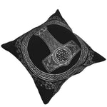 Mörk soffkudde med gråfärgat motiv föreställande den nordiske asaguden Tors verktyg