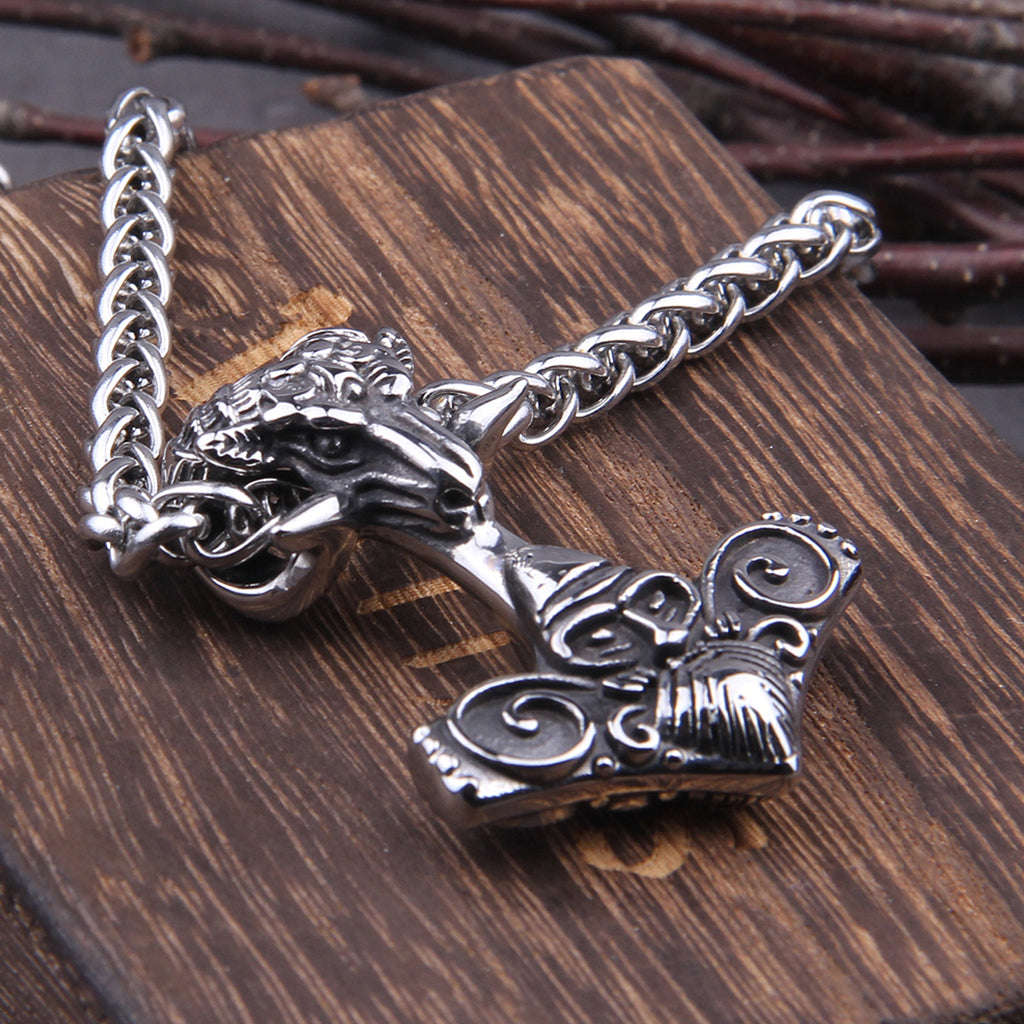 Fornnordiskt hammarsmycke i stål smyckat med bockhorn och Tors ansikte