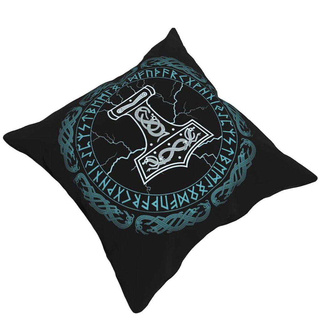 Mörk soffkudde med blåfärgat motiv av torshammare och runor
